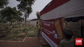 Petugas dan warga mendirikan tempat pemungutan suara (TPS) 034 RW 07 di kawasan TPU Karet Bivak. Jakarta, Selasa (16/4). (CNN Indonesia/Adhi Wicaksono)