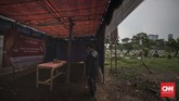 Petugas dan warga mendirikan tempat pemungutan suara (TPS) 034 RW 07 di kawasan TPU Karet Bivak. Jakarta, Selasa, (16/4). (CNN Indonesia/Adhi Wicaksono)