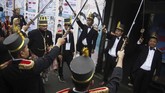 Petugas KPPS menyambut warga yang akan menggunakan hak pilihnya dengan prosesi pedang pora di TPS 27 Kampung Happy, Manahan, Solo, Jawa Tengah, Rabu (17/4). Aksi tersebut merupakan bentuk antusiasme warga setempat menyambut pesta demokrasi Pemilu 2019. (ANTARA FOTO/Maulana Surya)