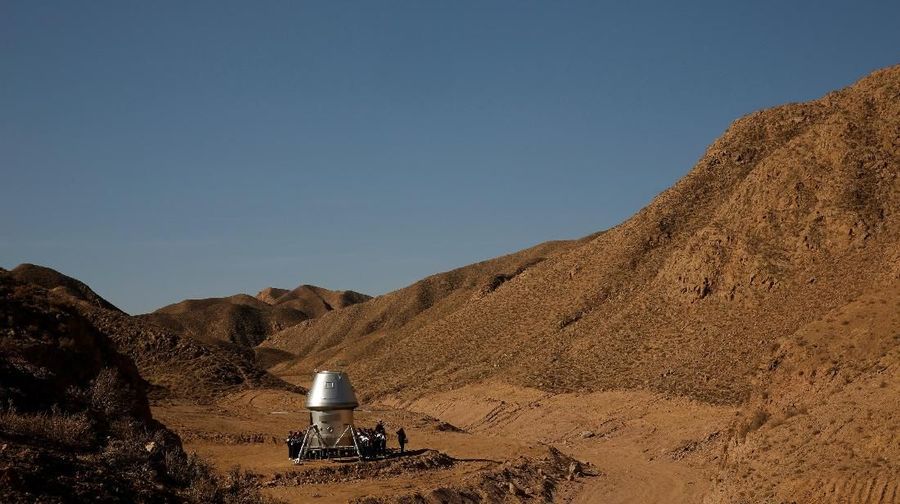 Students gather around a mock space capsule at the C-Space Project Mars simulation base in the Gobi Desert outside Jinchang, Gansu Province, China,  April 17, 2019.   REUTERS/Thomas Peter