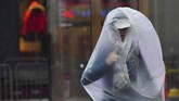 Seorang pelari coba menjaga agar tubuhnya tetap kering ketika mengikuti Marathon Boston di Massachusetts, Amerika Serikat. (REUTERS/Gretchen Ertl)