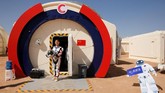 Seorang anggota staf berpose dalam setelan ruang angkasa tiruan di pangkalan simulasi C-Space Project Mars. (REUTERS/Thomas Peter)