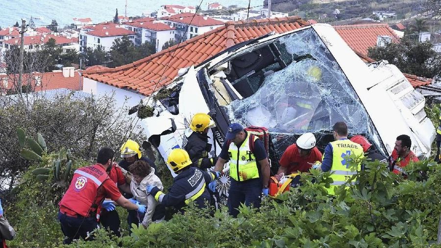 Petugas penyelamat menghadiri tempat kejadian setelah bus wisata jatuh di Canico di Pulau Madeira Portugal, Rabu, 17 April 2019. Bus wisata yang membawa turis Jerman jatuh di Pulau Madeira Portugal pada hari Rabu, menewaskan lebih dari beberapa lusin orang dan melukai beberapa lusin. yang lain, kata otoritas setempat. (Rui Silva / Aspress / Global Imagens via AP)