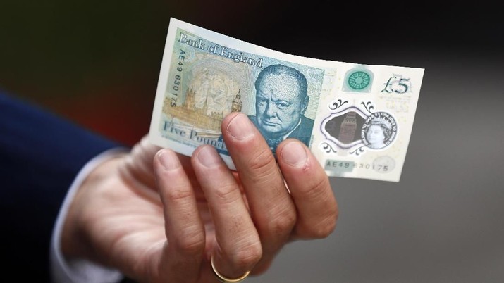 Bank of England governor Mark Carney poses with a new polymer five pound note at Whitecross Street Market in London, Britain September 13, 2016. REUTERS/Stefan Wermuth/File Photo
