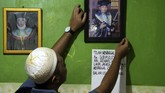 Anggota keluarga memperbaiki posisi foto Sudirdjo, seorang petugas KPPS yang meninggal dunia usai mendapatkan perawatan di rumah sakit di Bekasi, Jawa Barat, Selasa (23/4/2019). KPU Kota Bekasi mencatat sebanyak tiga orang petugas KPPS meninggal dunia usai bertugas di Pemilu serentak 2019. ANTARA FOTO/Risky Andrianto