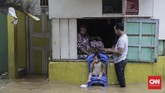 Sejumlah warga Jatinegara memilih bertahan di rumah dan enggan mengungsi. Mereka berharap banjir akan segera surut, Jumat (26/4) malam. (CNN Indonesia/Adhi Wicaksono)
