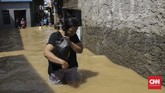 Warga di Balekambang Codet Jakarta Timur , membersihkan sisa-sisa lumpur akibat banjir (26/4). Kiriman debit air dari hulu (Bogor) membuat sejumlah kawasan di bantaran Kali Ciliwung meluap. (CNN Indonesia/Adhi Wicaksono)