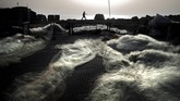 Seorang pria berjalan di belakang jaring tangkap ikan yang sedang mengering di Jaffa-Tel Aviv, Israel. (Photo by THOMAS COEX / AFP)