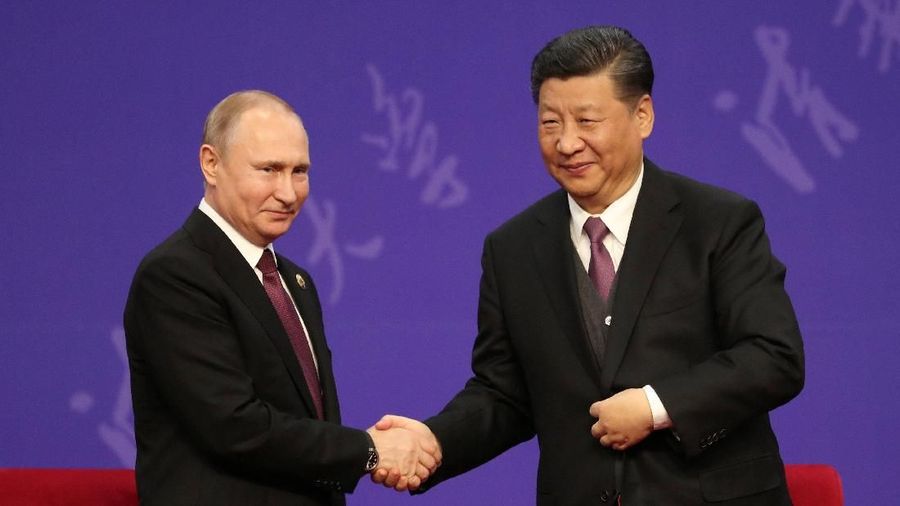 Presiden Rusia Vladimir Putin berjabat tangan dengan Presiden China Xi Jinping ( Kenzaburo Fukuhara/Pool via REUTERS)