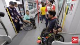 Petugas membantu seorang penyandang disabilitas naik ke kereta LRT di Stasiun LRT Veldrome, Jakarta, Sabtu (27/4). Kegiatan yang diikuti Jakarta Barrier Free Tourism (JBFT) tersebut untuk mengenalkan lebih dekat LRT.