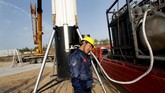 Insinyur Xiu Yu memegang sambil mendengarkan pipa setelah peluncuran uji coba roket LinkSpace yang dapat digunakan kembali di sebidang tanah kosong di Longkou, provinsi Shandong, Cina. (REUTERS/Jason Lee)