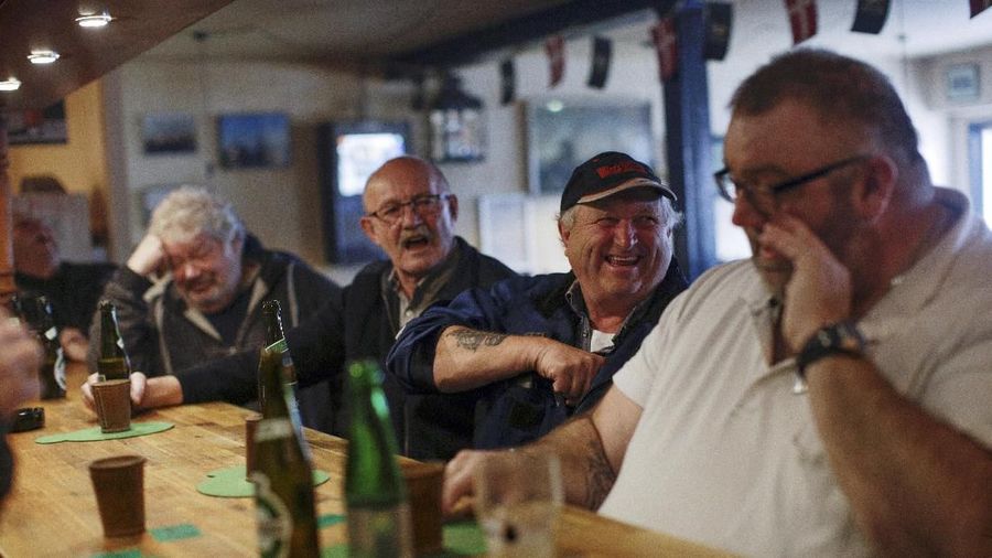 Para lelaki minum di Ankerpladsen, sebuah pub yang populer di kalangan nelayan tua dan pensiunan, di desa Thyboron di Jutland, Denmark, 14 Maret 2019. (REUTERS / Andrew Kelly)