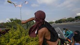 Seorang pendukung oposisi melemparkan bom molotov saat kerusuhan terjadi (Photo by Matias DELACROIX / AFP)