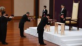 Mengenakan jas hitam berekor dan lencana kekaisaran, Naruhito berdiri di depan mimbar Aula Pinus alias Matsu no Mata. Ia diberikan tiga simbol kekaisaran: pedang, permata, lencana kasiar Jepang. Eranya yang bernama Reiwa pun dimulai. (Japan Pool/Pool via REUTERS)
