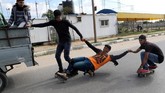 Beberapa anggota Gaza Skate Team, Mohammad Al-Sawalhe (23) dan Mustafa Sarhan (19), terlihat bahagia saat bercengkrama sembari berlatih di jalanan Gaza.