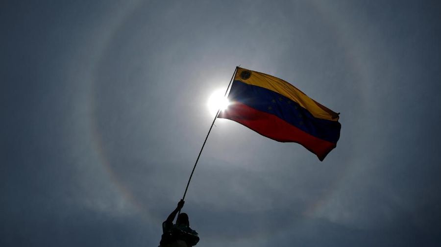 An opposition supporter holds a Venezuelan flag during a rally against the government of Venezuela's President Nicolas Maduro and to commemorate May Day in Caracas Venezuela, May 1, 2019. REUTERS/Ueslei Marcelino