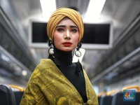 Model memperagakan busana Muslim Batik Tuban dan Tenun Ende Mahakarya Mustahik binaan BAZNAS di dalam Kereta Ekspres Bandara Internasional Soekarno-Hatta, Jakarta, Kamis (2/5/2019). (CNBC Indonesia/Andrean Kristianto)