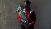 Seorang anggota Gaza Skate Team, Mustafa Sarhan (19), berpose bersama papan skateboard 'butut' kesayangannya.