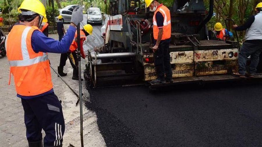Seorang pekerja berkerja mengaspal jalan raya. (Dok. PUPR)