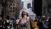 Seorang perempuan menyambut hangat sinar matahari saat mengikuti Parade Paskah dan Festival Topi di New York City, Amerika Serikat. (REUTERS/Stephanie Keith)
