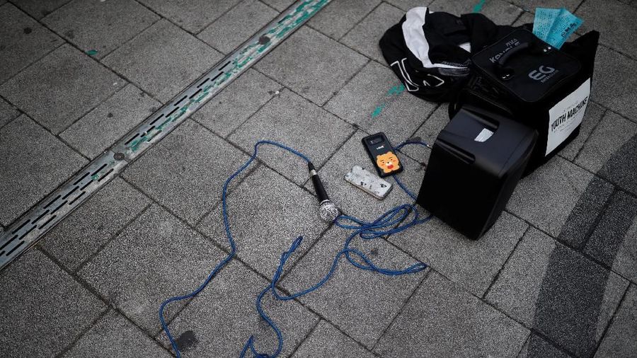Microphone and speakers lie on the ground as Japanese Yuuka Hasumi, 17, and Ibuki Ito, 17, also from Japan, who want to become K-pop stars, perform during their street performance in Hongdae area of Seoul, South Korea, March 21, 2019. REUTERS/Kim Hong-Ji   SEARCH 