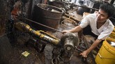 Pekerja memeriksa mesin blower gas sebelum memasak jagung di pusat pengolahan makanan ringan. (M Agung Rajasa).