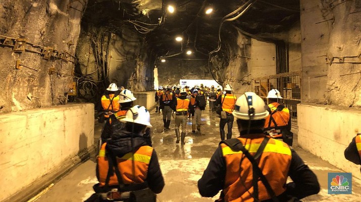 Tambang Emas Bawah Tanah Terbesar Dunia Milik Freeport Tambang legendaris Grasberg milik PT Freeport Indonesia yang berlokasi di Papua akan habis dan ditutup pada pertengahan tahun ini. Sebagai penggantinya, produksi emas, perak, dan tembaga Freeport akan mengandalkan tambang bawah tanah.
Tambang bawah tanah ini lokasinya persis di bawah Grasberg. Penambangan bawah tanah menggunakan metode block caving, yang merupakan cara penambangan bawah tanah dengan efisiensi sumberdaya yang tinggi untuk melakukan penambangan, di mana blok-blok besar bijih di bawah tanah dipotong dari bawah sehingga bijih tersebut runtuh akibat gaya beratnya sendiri.
Tambang bawah tanah ini sudah direncakan sejak 2004 dan terus dikembangkan hingga sekarang. Ada dua blok tambang bawah tanah Freeport yang jadi andalan saat ini, yaitu Deep Ore Zone (DOZ) dan Big Gossan. Saat ini tengah dikembangkan juga blok bernama Deeep Mill Level Zone (DMLZ).
Di dalam tambang ini, terbangun jalan sepanjang 650 kilometer (km), yang berarti panjangnya lebih dari jarak Jakarta ke Yogyakarta. Jalan di dalam tambang bawah tanah ini akan terus dibangun hingga 1.000 km atau seperti Jakarta ke Surabaya.
Data terakhir produksi rata-rata dari tambang bawah tanah ini adalah 80.000 ton ore (bijih tambang) per hari.
Sampai dengan 2019, Freeport telah mengeluarkan investasi hingga US$ 16 miliar atau dengan kurs, saat ini sekitar Rp 224 triliun untuk pengembangan tambang bawah tanah yang akan menjadi andalan mereka. Ke depan, Freeport yang saat ini 51% sahamnya dimiliki oleh PT Indonesia Alumunium (Inalum) akan mengucurkan lagi investasi hingga US$ 15 miliar atau sekitar Rp 210 triliun untuk tambang bawah tanah tersebut. (CNBC Indonesia/Wahyu Daniel)
