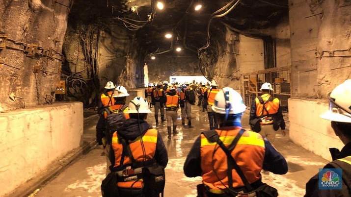 Tambang Emas Bawah Tanah Terbesar Dunia Milik Freeport Tambang legendaris Grasberg milik PT Freeport Indonesia yang berlokasi di Papua akan habis dan ditutup pada pertengahan tahun ini. Sebagai penggantinya, produksi emas, perak, dan tembaga Freeport akan mengandalkan tambang bawah tanah.
Tambang bawah tanah ini lokasinya persis di bawah Grasberg. Penambangan bawah tanah menggunakan metode block caving, yang merupakan cara penambangan bawah tanah dengan efisiensi sumberdaya yang tinggi untuk melakukan penambangan, di mana blok-blok besar bijih di bawah tanah dipotong dari bawah sehingga bijih tersebut runtuh akibat gaya beratnya sendiri.
Tambang bawah tanah ini sudah direncakan sejak 2004 dan terus dikembangkan hingga sekarang. Ada dua blok tambang bawah tanah Freeport yang jadi andalan saat ini, yaitu Deep Ore Zone (DOZ) dan Big Gossan. Saat ini tengah dikembangkan juga blok bernama Deeep Mill Level Zone (DMLZ).
Di dalam tambang ini, terbangun jalan sepanjang 650 kilometer (km), yang berarti panjangnya lebih dari jarak Jakarta ke Yogyakarta. Jalan di dalam tambang bawah tanah ini akan terus dibangun hingga 1.000 km atau seperti Jakarta ke Surabaya.
Data terakhir produksi rata-rata dari tambang bawah tanah ini adalah 80.000 ton ore (bijih tambang) per hari.
Sampai dengan 2019, Freeport telah mengeluarkan investasi hingga US$ 16 miliar atau dengan kurs, saat ini sekitar Rp 224 triliun untuk pengembangan tambang bawah tanah yang akan menjadi andalan mereka. Ke depan, Freeport yang saat ini 51% sahamnya dimiliki oleh PT Indonesia Alumunium (Inalum) akan mengucurkan lagi investasi hingga US$ 15 miliar atau sekitar Rp 210 triliun untuk tambang bawah tanah tersebut. (CNBC Indonesia/Wahyu Daniel)