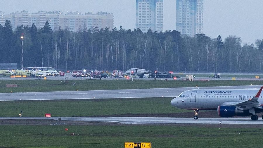 Pesawat Sukhoi SSJ-100 dari Aeroflot Airlines, tengah, terlihat setelah pendaratan darurat di bandara Sheremetyevo di Moskow, Rusia, Minggu, 5 Mei 2019. Pesawat milik perusahaan penerbangan nasional Rusia Aeroflot mendarat dengan api di bandara. (AP / Alexander Zemlianichenko)