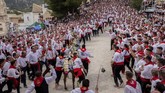 Peraturan dalam festival ini sederhana saja. Empat pria memakai celana hitam, kemeja putih dan syal merah berlari di sebelah kuda, menggantung di atasnya saat ia berlari menaiki jalan yang curam menuju kastil. (AP Photo/Bernat Armangue)