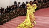 Serena Williams ikut mencuri perhatian publik di Met Gala 2019. Petenis satu ini tampil mengenakan gaun off-shoulder Versace berwarna kuning menyala berhias daun-daun merah muda. Gaun cantik itu dipadukan secara sempurna dengan sneakers putih kolaborasi Nike dan Off-White. (REUTERS/Andrew Kelly)