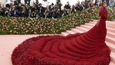 Bak burung raksasa berjalan, Cardi B menyapuh karpet merah dengan gaun panjang dan lebar berwarna merah lengkap dengan detail bulu berwarna serupa. Tampilan juga dilengkapi oleh headpiece berhiaskan berlian merah dan sarung tangan warna senada. (REUTERS/Andrew Kelly)