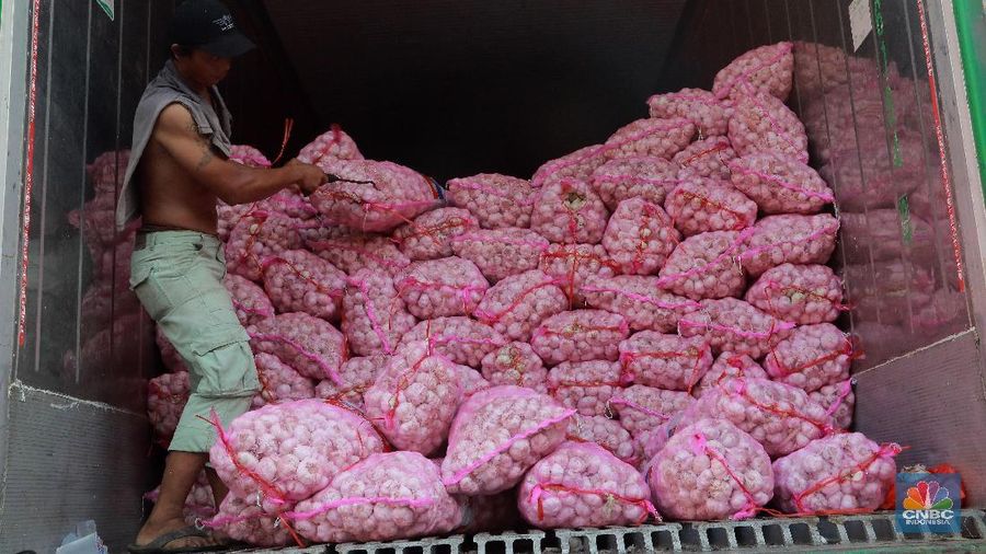 Kuli panggul mengangkat karung bawang putih di Pasar Kramat jati,  Jakarta Timur, Selasa 7/5. Pedagang Los Eceran dikawasan pasar Kramat jati menjual bawang putih Rp 35.000 per kilogram turun dari harga sebelumnya Rp45.000 karena pasokan bawang putih sudah sedikit stabil. Harga bawang putih yang dijual Eceran seharga Rp50. 000 sampai Rp60. 000. Harga bawang  merah naik sedikit dari Rp 20.000 menjadi Rp 22. 000 harga Los Eceran. Harga Cabe merah turun menjadi Rp 25.000 turun saat kemarin naik Rp 30.000 sampai Rp 40.000.   (վ/Muhammad Sabki)