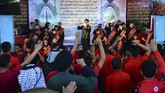 Sorak-sorai terdengar ketika rapper berpakaian hitam mulai menyerukan lirik di atas panggung. (Haidar HAMDANI / AFP)