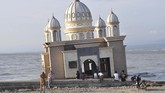Warga menunggu waktu berbuka puasa di Masjid Terapung yang rusak akibat gempa dan tsunami di Palu, Sulawesi Tengah, Senin (6/5). (ANTARA FOTO/Mohamad Hamzah)