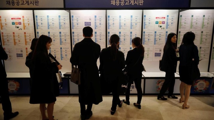 Jobseekers look at recruitment advertisements during the 2018 Japan Job Fair in Seoul, South Korea, November 7, 2018. Picture taken on November 7, 2018. To match Insight SOUTHKOREA-JOBS/KMOVE  REUTERS/Kim Hong-Ji