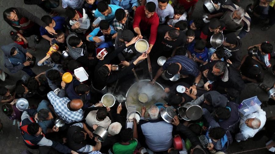 Buka Puasa di Berbagai Negara (Palestinians gather to get soup offered for free during the Muslim fasting month of Ramadan, in Gaza City May 9, 2019. REUTERS/Mohammed Salem)