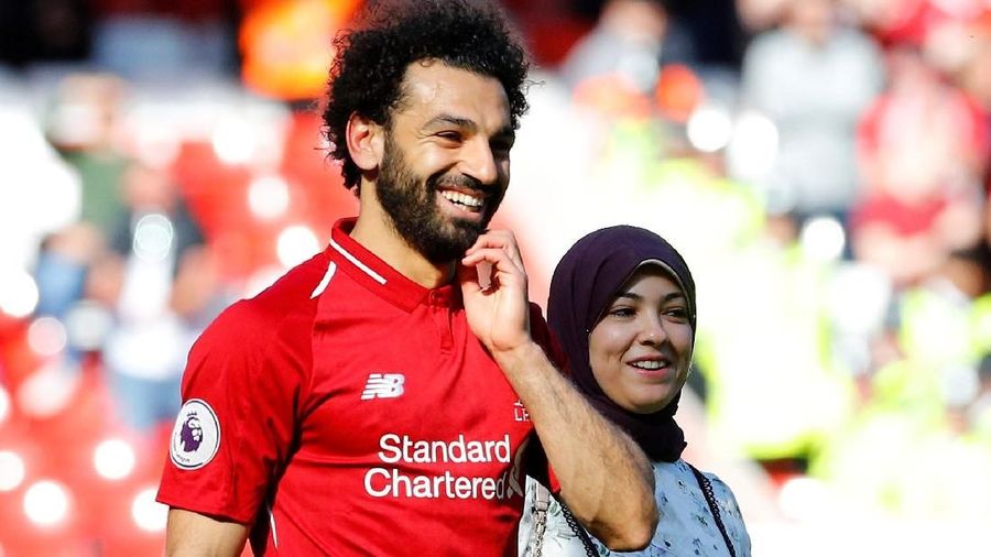 Pemain Liverpool Mohamed Salah berjalan di sekitar lapangan bersama istrinya, Magi Salah, usai pertandingan Liverpool vs Wolverhampton Wanderers REUTERS / Phil Noble