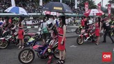 Seperti balapan MotoGP, road race di Indonesia juga menggunakan jasa gadis payung. Biasanya gadis payung hadir saat road race memasuki babak final. (CNN Indonesia/M Arby Rahmat)