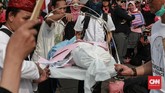 Aksi teatrikal menggotong keranda mayat sebagai simbol matinya demokrasi untuk para perempuan yang tergabung dalam Aksi PIB, di seberang Istana Merdeka. (CNN Indonesia/Andry Novelino)