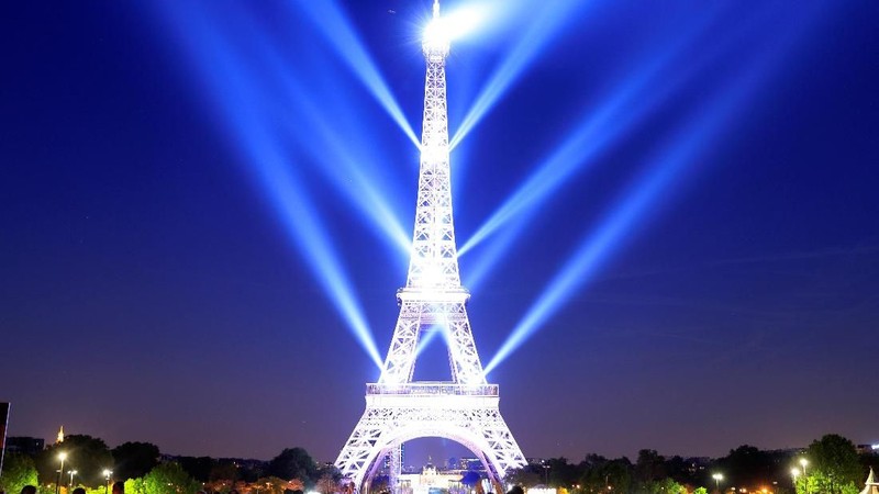 Rayakan hari jadi ke-130, menara Eiffel menampilkan kerlap-kerlip kemewahan lampunya pada malam hari.