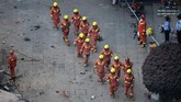 Petugas pemadam kebakaran dan tim penyelamat berkejaran dengan waktu untuk menyelamatkan korban. (Photo by Hector RETAMAL / AFP)