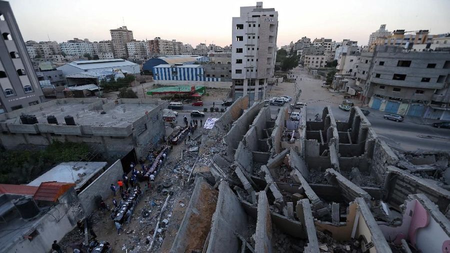 Palestinians break their fast by eating the Iftar meals during the holy month of Ramadan, near the rubble of a building recently destroyed by Israeli air strikes, in Gaza City May 18, 2019. REUTERS/Ibraheem Abu Mustafa