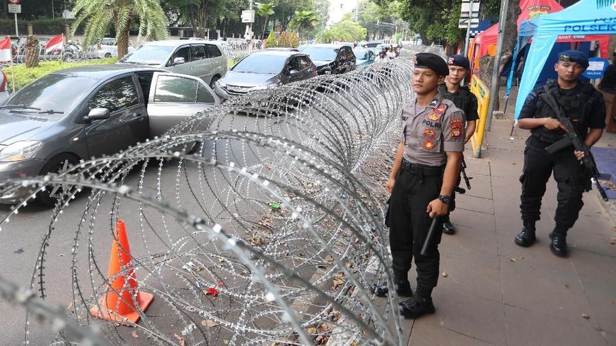 Anggota kepolisian berjaga melakukan pengamanan di depan Gedung KPU,  Jakarta, Senin,  20Mei 2019. Penjagaan ini juga untuk mewaspadai ancaman terorisme yang mungkin terjadi juga keamanan jelang 22 Mei 2019. Sebagai informasi, tahapan rekapitulasi nasional yang dilakukan KPU sejauh ini menunjukkan pasangan nomor urut 01 Joko Widodo dan Ma'ruf Amin masih unggul atas Prabowo Subianto dan Sandiaga Uno. Meskipun tanggal pengumuman dikabarkan menjadi target teroris dan akan ada gerakan demo besar-besaran, namun KPU menegaskan jadwal pengumuman tak akan berubah, yaitu tetap 22 Mei 2019.  (CNBC Indonesia/Muhammad Sabki)