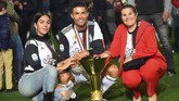 Cristiano Ronaldo berpose bersama sang pacar, Georgina Rodriguez, dan ibunda, Dolores Aveiro, dengan trofi Liga Italia. Ronaldo jadi pemain pertama yang juara di Liga Italia, Liga Spanyol, dan Liga Inggris. (REUTERS/Massimo Pinca)