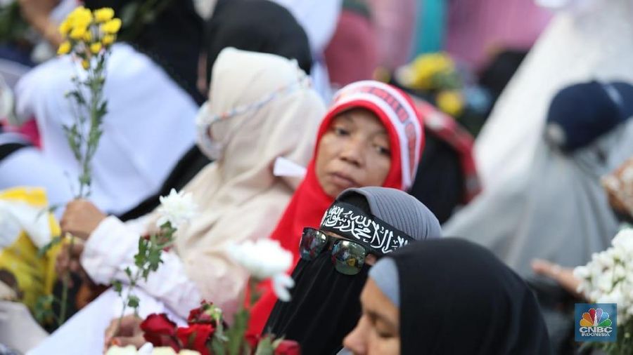 Dalam aksinya mereka membagi-bagikan bunga kepada polisi yang berjaga.