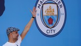 Pep Guardiola melambaikan tangan kepada fan Man City di atas panggung perayaan juara. (Action Images via Reuters/Lee Smith)