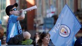 Seorang anak mengenakan kostum replika Manchester City meniup terompet menyambut kedatangan skuat The Citizens. (Action Images via Reuters/Carl Recine)