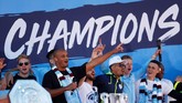 Para pemain Manchester City berada di panggung bersama seluruh trofi. (Action Images via Reuters/Lee Smith)