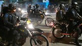 Pasukan bermotor polisi juga sempat dikerahkan untuk mengurai massa. Hal ini efektif namun massa kembali berkumpul di tempat lain. (BAY ISMOYO/AFP)